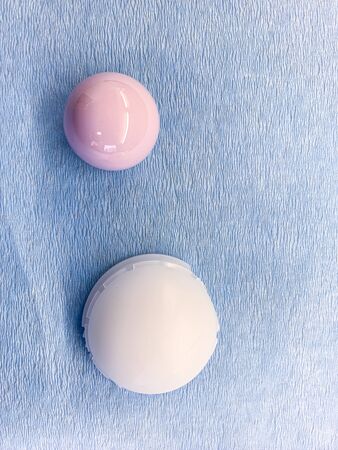 a duo head hip prosthesis is placed on a light blue cloth, with the cup made of plastic and the head made of ceramicsの写真素材