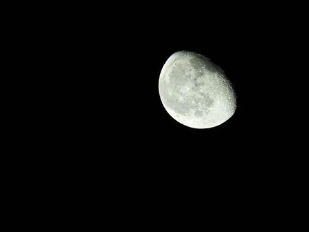 a close-up of the waning three-quarter moon in the starry night skyの写真素材