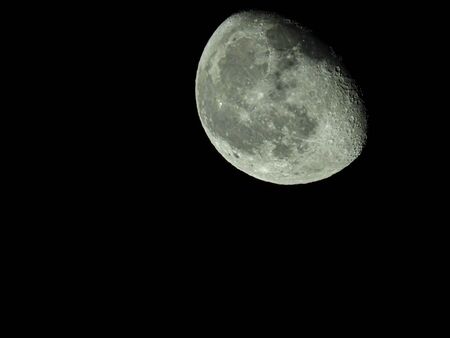a close-up of the waning three-quarter moon in the starry night skyの写真素材