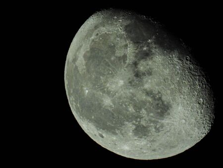 a close-up of the waning three-quarter moon in the starry night skyの写真素材
