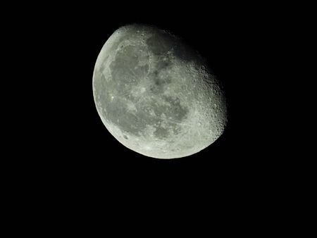 a close-up of the waning three-quarter moon in the starry night skyの写真素材