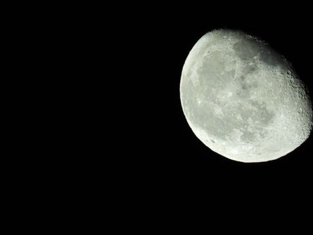 a close-up of the waning three-quarter moon in the starry night skyの写真素材