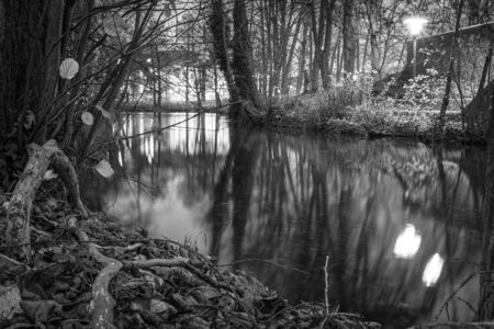 a black and white photograph of a river landscape in the darknessの写真素材