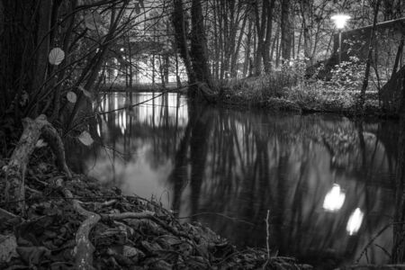 a black and white photograph of a river landscape in the darknessの写真素材