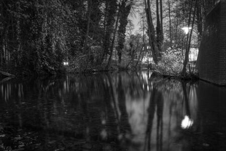 a black and white photograph of a river landscape in the darknessの写真素材