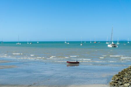 at the beach of Arlie Beach in Australia you can see many sailboats lying in the bayの写真素材