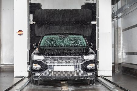 a black car stands in a car wash and is washedの写真素材