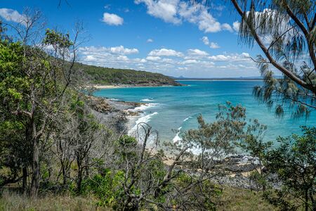 the beautiful beach of Noosa on the sunshine coast in Australia with beautiful weather and blue sky with white cloudsの写真素材