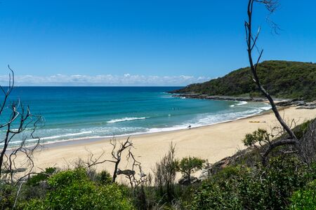the beautiful beach of Noosa on the sunshine coast in Australia with beautiful weather and blue sky with white cloudsの写真素材