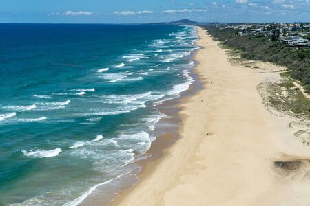 the beautiful beach of Noosa on the sunshine coast in Australia with beautiful weather and blue sky with white cloudsの写真素材