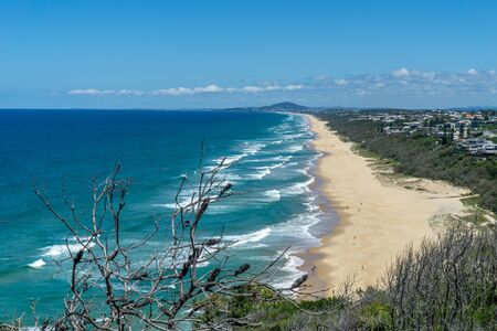 the beautiful beach of Noosa on the sunshine coast in Australia with beautiful weather and blue sky with white cloudsの写真素材