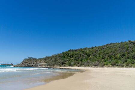 the beautiful beach of Noosa on the sunshine coast in Australia with beautiful weather and blue sky with white cloudsの写真素材