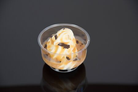a sundae with vanilla ice cream and sauce on a dark baseの写真素材