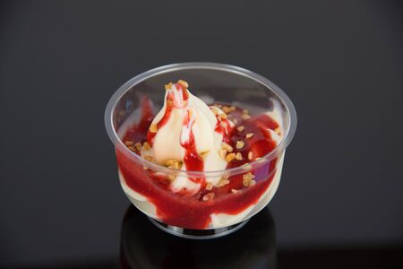 a sundae with vanilla ice cream and sauce on a dark baseの写真素材