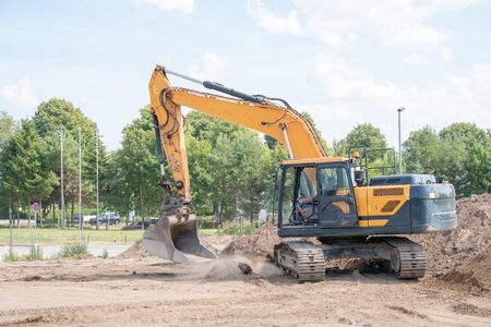 an excavator prepares the construction site for the placement of concrete columns