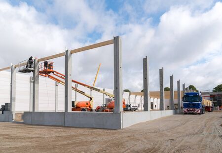 on a building site wooden trusses are built on the concrete columns of a factory building