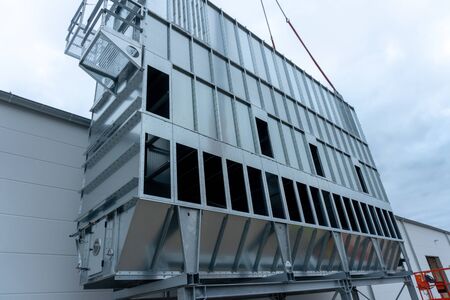 a huge extraction system for wood chips is installed on a factory building on a construction site