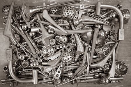 in one box there are many different explanted prostheses and letters made of steelの写真素材