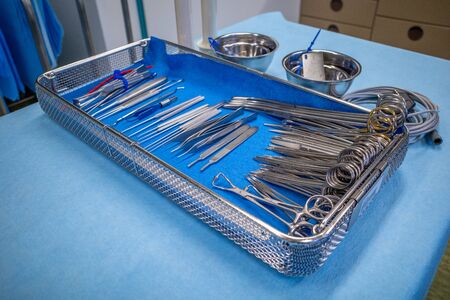 in an operating room, there's a sieve for hand surgery on a blue sheet
