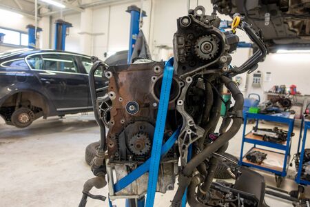 in a garage the engine of a car was removed to be repaired
