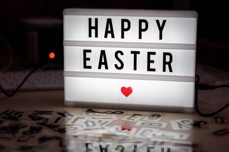 on a white illuminated cinema sign with black letters Happy Easter