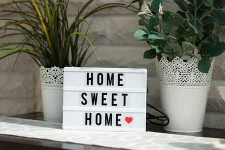 on a white illuminated cinema sign with black letters Home sweet home