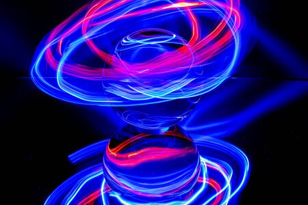 red-blue rings surround a crystal clear glass ball on a mirror
