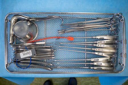 a cleaned and disinfected instrument sieve for performing a uterus scraping lies on a blue cloth