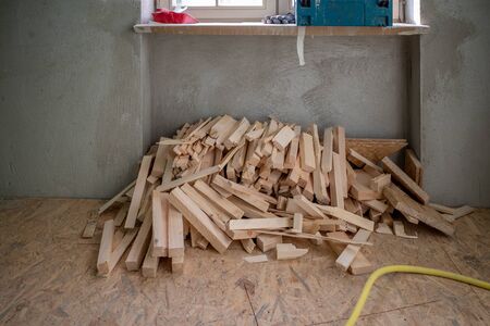 there's a pile of wood under a window on a construction site