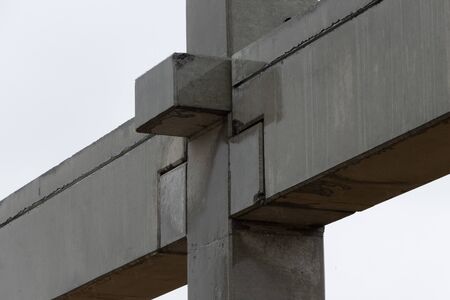 On a large construction site, concrete cross beams are connected to concrete columns for a factory buildingの写真素材