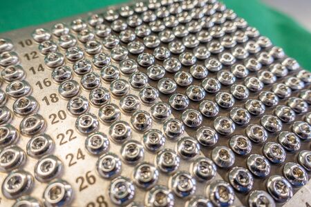 on an operating table is a tray with various surgical steel screws