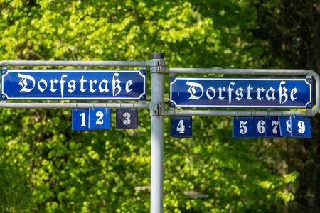 in a German village there is a street sign with the inscription Dorfstrasse in old lettersの写真素材