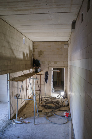 a mason works on a scaffold in a room without windowsのeditorial素材
