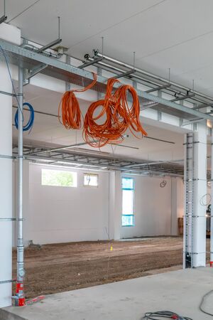 Inside a construction site many cables hang from the ceiling