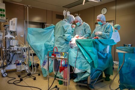 in an operating room, a caesarean section is performed by a surgical team