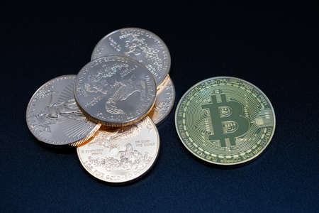 one gold Bitcoin coin is worth 10000 dollars to one stack of gold dollarsの写真素材