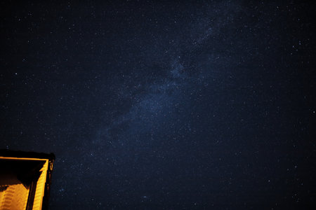 above a residential house many stars shine in the night sky