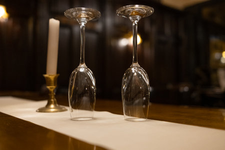 Two simple wine glasses stand next to each other on a tableの写真素材