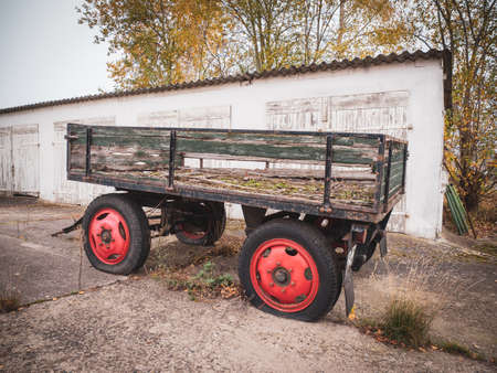 on a farm there is an old trailer, which is broken and has flat tires