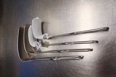 four surgical abdominal retractors lie on a silver base