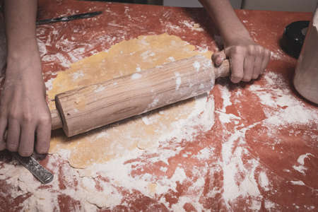 Christmas cookies are cut out of a cookie dough with a glassの写真素材