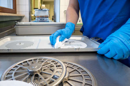 a member of an operating department cleans instrument containers with a cleaning clothの写真素材