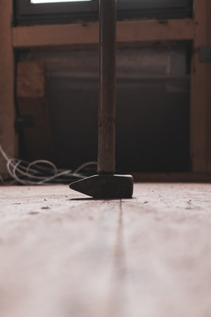 a big sledgehammer stands on a wooden floor of a construction siteの写真素材