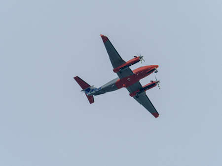 in the gray sky flies a propeller transport plane
