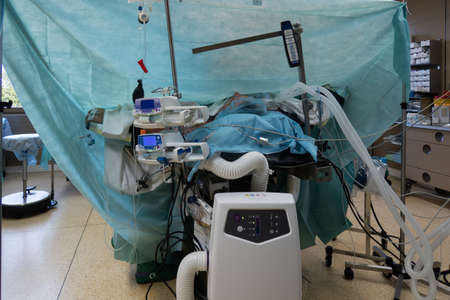 a patient lies ventilated under general anesthesia on an operating table