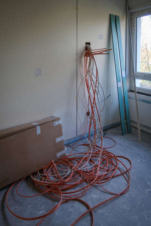 many cables hanging out of a wall on a construction site