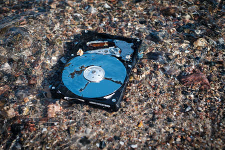 a computer rest disk lies in the shallow clear water of the sea