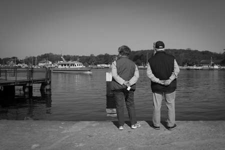 an old couple stands at the harbor of Luebeck-Travemuende and looks at the shipsの写真素材