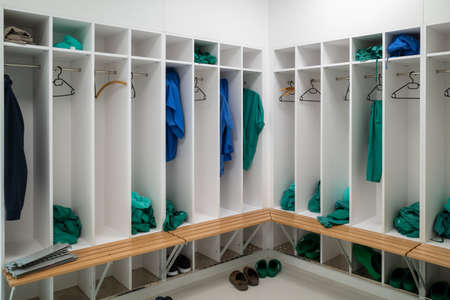 green and blue surgical gowns hang in an operating room in a hospital