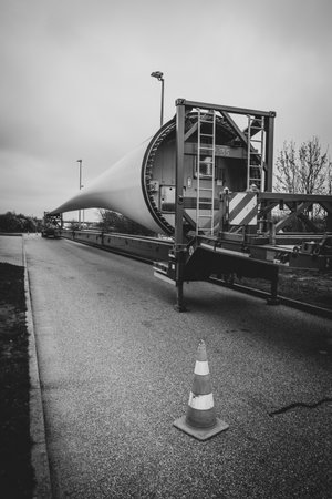 the wing of a wind turbine lies on a trailer on the highwayのeditorial素材
